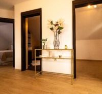 Innenraum eines Einfamilienhauses mit Holzboden und einer Auszeichnung vom Immobilienbüro.