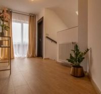 Ein Einfamilienhaus mit elegantem Blumendekor und einem Boden in Holzoptik.