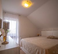 Schlafzimmer im Einfamilienhaus mit Dekorationen, Bett und sanfter Beleuchtung.