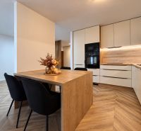 Die Küche in einer 3-Zimmer-Wohnung mit einem Holzboden und einem dekorativen Tisch.