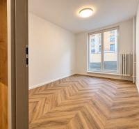 Innenraum einer 3-Zimmer-Wohnung mit Holzboden, weißen Wänden, großem Fenster.