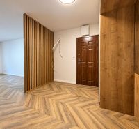 Innenraum einer 3-Zimmer-Wohnung mit Holzboden und Holzwand.