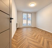 Ein Zimmer in einer 3-Zimmer-Wohnung mit einem Boden in Holzoptik und einem französischen Fenster.