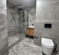 Badezimmer in einer 3-Zimmer-Wohnung mit einer modernen Duschkabine und eleganten Fliesen.