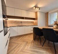 Küche in einer 3-Zimmer-Wohnung mit Holzboden und Esstisch.