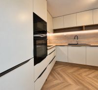 Küchenzeile mit weißen Schränken und Holzdekor in einer 3-Zimmer-Wohnung.