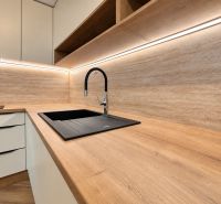 Küche in einer 3-Zimmer-Wohnung mit Holzboden und weißen Schränken.