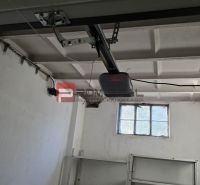 Innenraum einer Garage mit weißen Wänden, einem Fenster und einem Garagentoröffner.