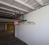 Innenraum einer Garage mit einem automatischen Tor und Betonboden.