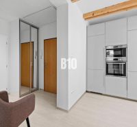 Helle Innenausstattung einer 2-Zimmer-Wohnung mit weißen Wänden, Geräten und Spiegel.