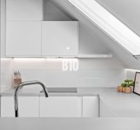 Eine Küche im Dachgeschoss mit Dachfenster und minimalistischem Design in einer 2-Zimmer-Wohnung.