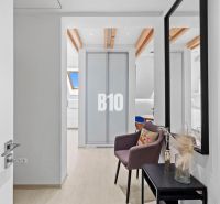 Der Flur in der 2-Zimmer-Wohnung mit einem Boden in Holzoptik und einem Spiegel an der Wand.