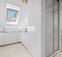 Helle Küchenzeile mit Fenster und Holzboden in einer 2-Zimmer-Wohnung.