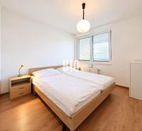 Schlafzimmer in einer 2-Zimmer-Wohnung mit Bett, Nachttisch und Holzboden.