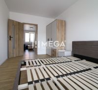 Schlafzimmer in einer 2-Zimmer-Wohnung mit Holzboden und einfacher Einrichtung.