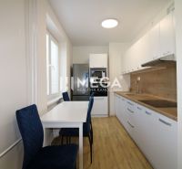 Küche mit Tisch und Holzboden in einer 2-Zimmer-Wohnung.