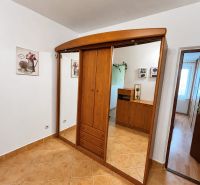 In einer 3-Zimmer-Wohnung sehen wir einen Einbauschrank mit einem verschiebbaren Spiegel und Fliesen.