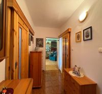 Flur in einer 3-Zimmer-Wohnung mit Holzboden und Holzmöbeln.
