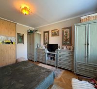 Schlafzimmer in einer 3-Zimmer-Wohnung mit dekorativer Beleuchtung, Schrank und Kommode.