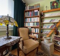Ein Bücherregal mit vielen Büchern und Dekorationen in einer 3-Zimmer-Wohnung, Boden mit Holzdekor.