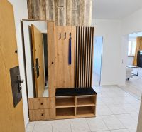 Eingangsflur mit Holzmöbeln und Fliesen in einer 2-Zimmer-Wohnung.