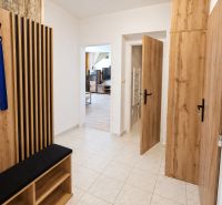 Flur mit Garderobe und Eingang zum Wohnzimmer in einer 2-Zimmer-Wohnung, Holzelemente.