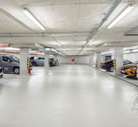 Tiefgarage mit markierten Parkplätzen und geparkten Autos.