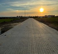 Ein befestigter Weg in den Weinbergen in Senica bei Dämmerung mit Blick auf die Stadt.