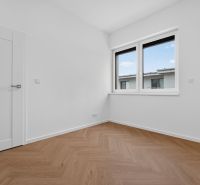 Ein Zimmer in einer 3-Zimmer-Wohnung mit einem Fenster und einem Boden in Holzoptik.