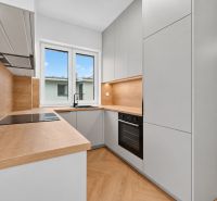 Küche in einer 3-Zimmer-Wohnung mit Holzboden und modernen Geräten.