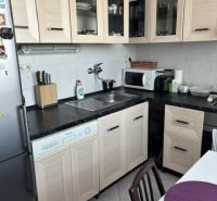 Küche in einer 2-Zimmer-Wohnung mit Holzmöbeldekor und hellen Fliesen.