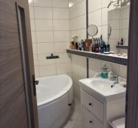 Badezimmer in einer 2-Zimmer-Wohnung mit Badewanne, Waschbecken und weißen Fliesen.
