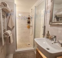 Badezimmer im Einfamilienhaus mit begehbarer Dusche, dekorativem Spiegel und gemütlicher Beleuchtung.