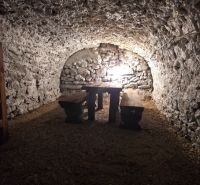 Steinkeller im Einfamilienhaus mit Holzbänken und Tisch.
