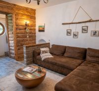 Wohnzimmer in einem Einfamilienhaus mit rustikalen Elementen und einem bequemen Sofa.