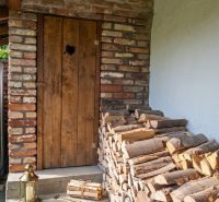 Holztür mit einem Stapel Holz beim Einfamilienhaus in Dobrá Voda, Straße 240.