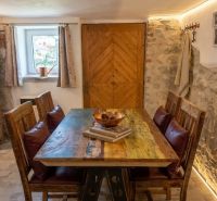 Esstisch mit Holzdekor und Steinwand in einem Einfamilienhaus.