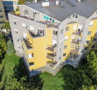Ein Wohnhaus mit gelber Fassade, umgeben von Grün, im Slávičie údolie in Bratislava.