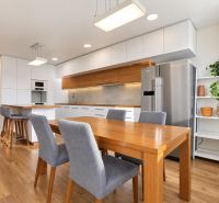 Küche in einer 3-Zimmer-Wohnung mit Holzboden, hellen Möbeln und dekorativen Pflanzen.