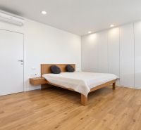 Helles Schlafzimmer mit Doppelbett und Holzboden in einer 3-Zimmer-Wohnung.