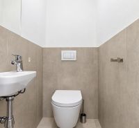 Toilette mit Waschbecken in einer 3-Zimmer-Wohnung, beige Fliesen und weiße Sanitärobjekte.