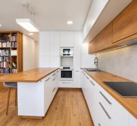 Küche in einer 3-Zimmer-Wohnung mit weißen Schränken, Holzboden und Bücherregal.