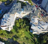 Draufsicht auf einen Gebäudekomplex mit Grünflächen und Parkplätzen in Bratislava.