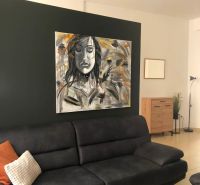 Wohnzimmer mit grauem Sofa, auffälligem Bild und hellem Fliesenboden in einer 2-Zimmer-Wohnung.