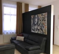 Wohnzimmer in einer Zweizimmerwohnung mit einem Sofa und einem Bild an der Wand.
