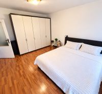 Schlafzimmer mit Holzboden und großem Schrank in einer Einzimmerwohnung.