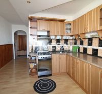 Küche in einer 3-Zimmer-Wohnung mit Holzboden und gebogenem Schrank.