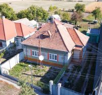 Ein Einfamilienhaus in Kráľov Brod mit einem traditionellen Dach, umgeben von Gärten und Feldern.