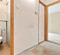 Flur einer 2-Zimmer-Wohnung mit freiliegender Wand, Toilette und Zugang zum Raum.