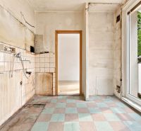 Küche in einer 2-Zimmer-Wohnung ohne Ausstattung, abgenutzte Wände, Blick nach draußen.